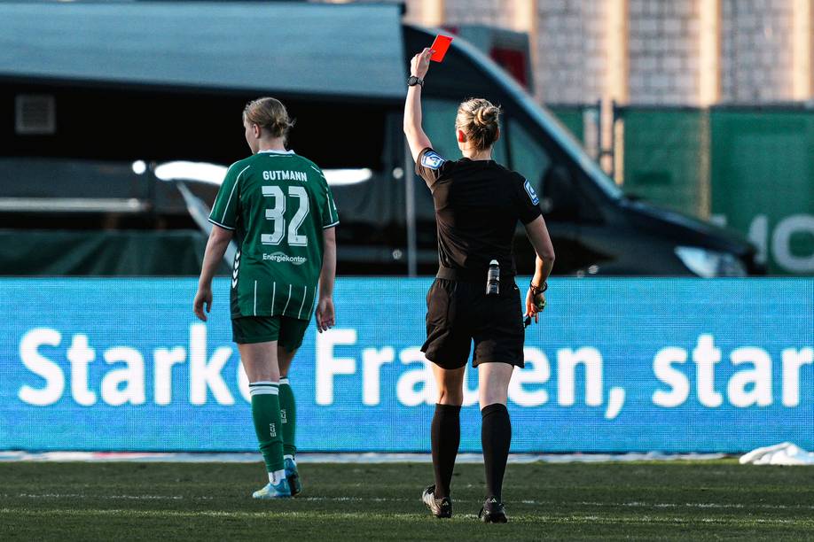 Sarah Gutmann ist von hinten im grünen Trikot zu sehen, die Schiedsrichterin zeigt ihr die Rote Karte.