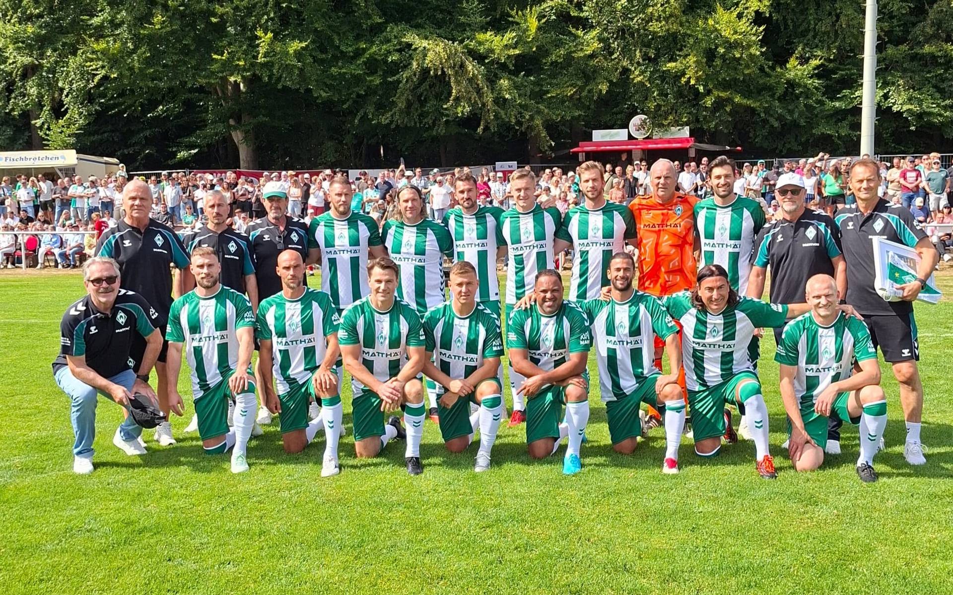Ein Mannschaftsfoto der Werder Legenden im Heimtrikot. Im Hintergrund sind Fans zu sehen.