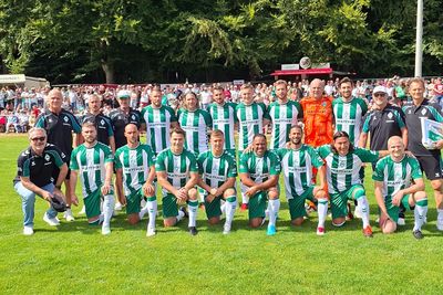 Ein Mannschaftsfoto der Werder Legenden im Heimtrikot. Im Hintergrund sind Fans zu sehen.