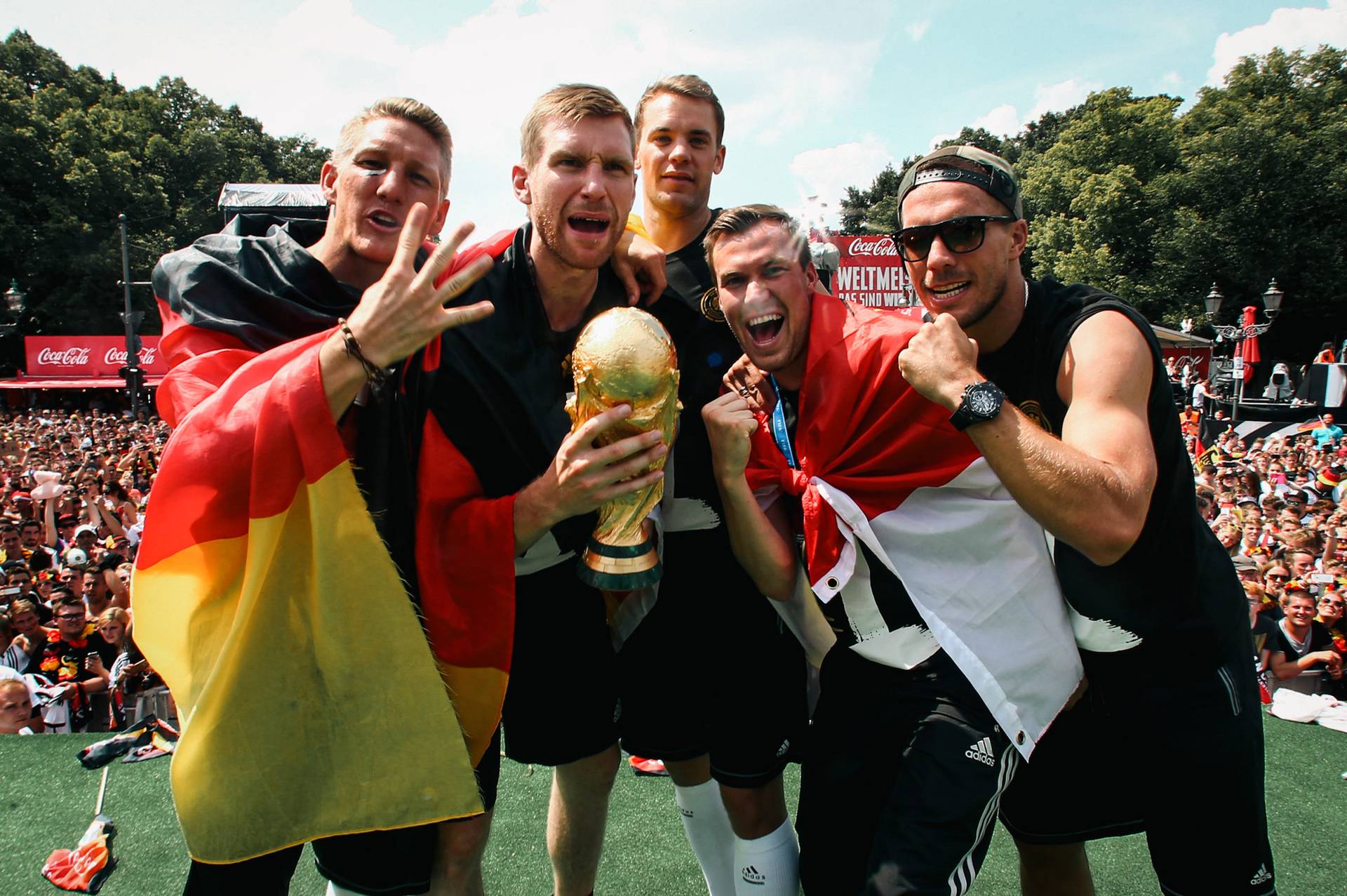 Per Mertesacker mit dem WM-Pokal in der Hand, um ihn herum Bastian Schweinsteiger, Manuel Neuer, Kevin Großkreutz und Lukas Podolski.