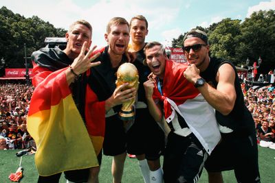 Per Mertesacker with the World Cup trophy in his hands, surrounded by Bastian Schweinsteiger, Manuel Neuer, Kevin Großkreutz and Lukas Podolski.