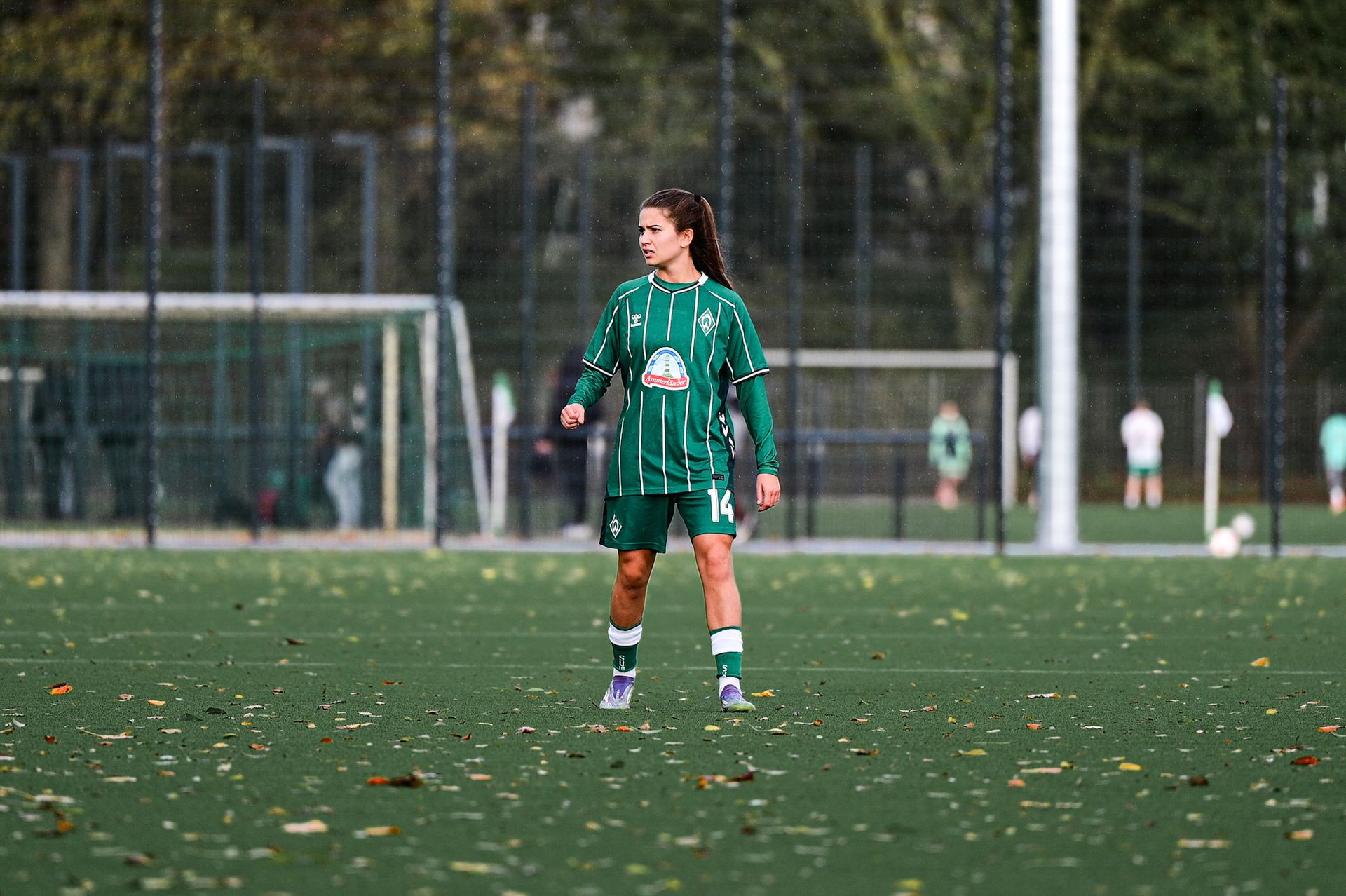 Melina Kunkel steht auf dem Platz im grünen Heimtrikot und schaut zur Seite.