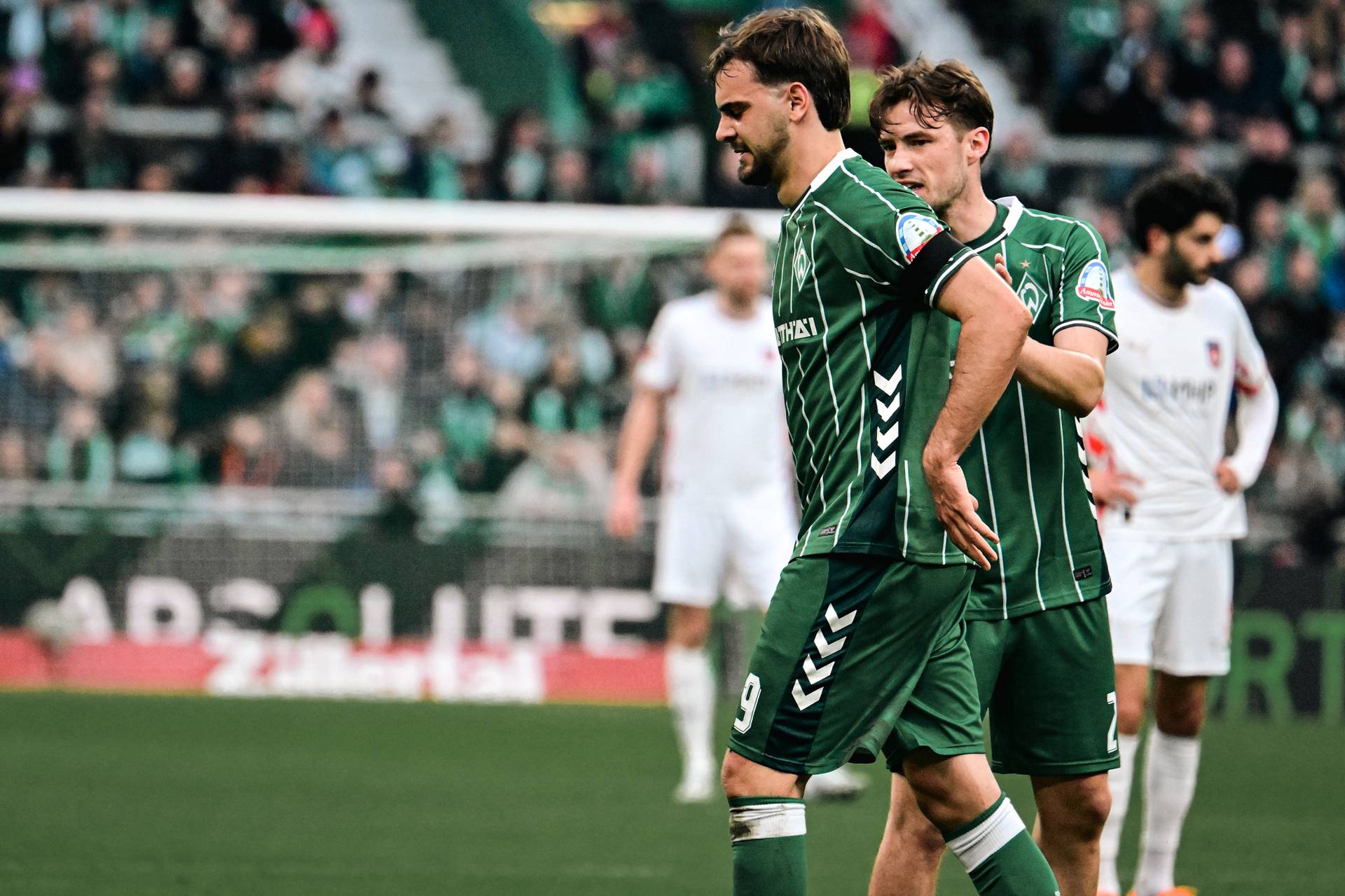 Jovan Milošević fässt sich mit schmerzverzerrtem Gesicht an den Rücken.