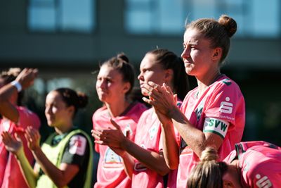 Fußballerinnen in rosa Trikots klatschen im strahlenden Sonnenlicht, wirken konzentriert, und die SVW-Logos sind deutlich zu erkennen.