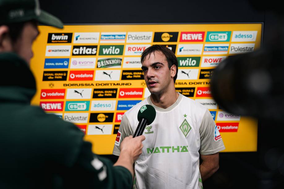 Milošević im Werder-Trikot in der Mixed Zone, vor ihm das WERDER.TV-Mikrofon.