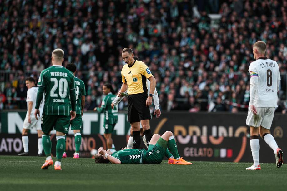 Sören Storks steht im Weserstadion auf dem Platz, Jens Stage liegt auf dem Boden.