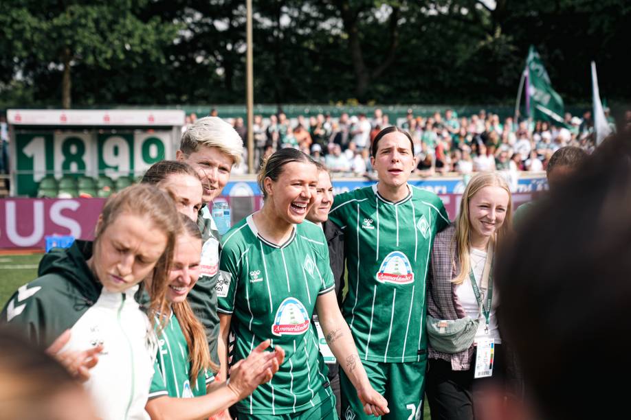 Larissa Mühlhaus lacht im Kreis mit der Mannschaft.