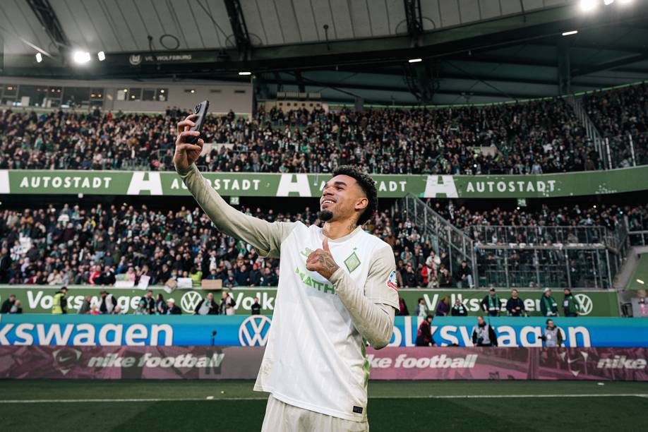 Justin Njinmah posiert für ein Selfie vor dem Gästeblock.