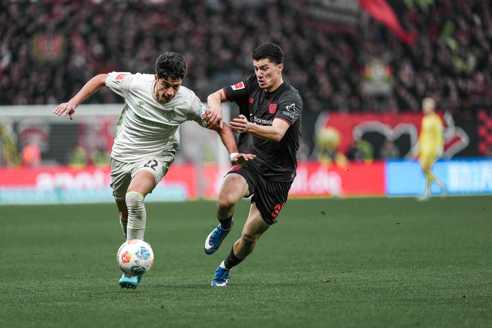 Julian Malatini im Duell mit Leverkusen Maza. Er hat den Ball am Fuß und wird von seinem Gegenspieler am Arm gepackt.
