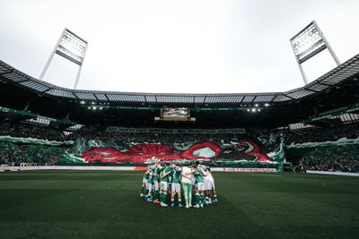 Der Mannschaftskreis vor der Kurve, in der eine Choreo vorgetragen wird.