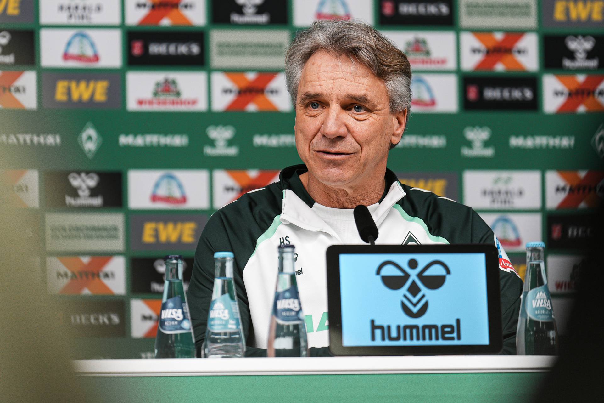 Horst Steffen sitzt auf dem Podium im Pressekonferenzraum.