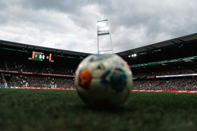 Ein Ball liegt auf dem Platz, im Hintergrund ein Flutlichtmast des Weserstadions.