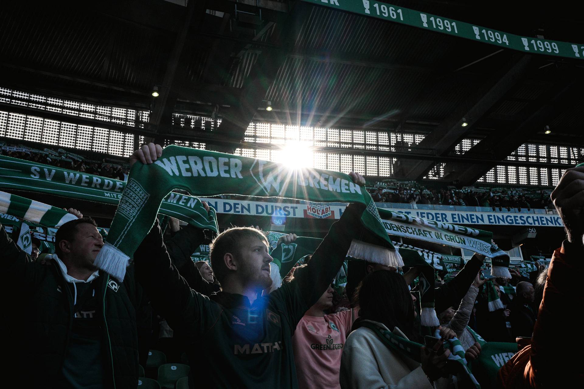 Fans mit Werder-Schal auf der Tribüne.