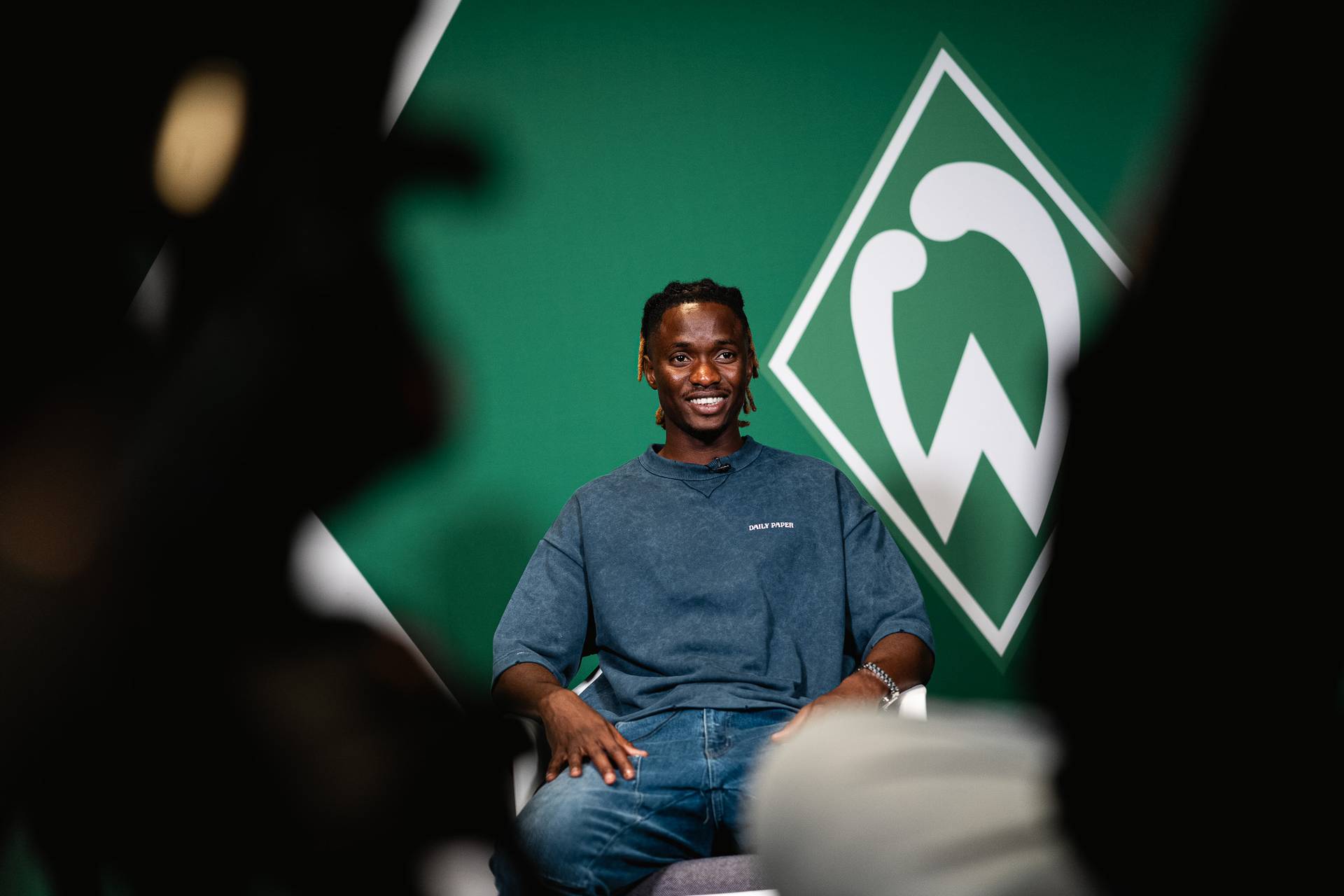 Moussa Ndiaye vor einer Werder-Raute.