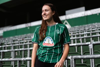 Mara Alber steht in der Ostkurve und trägt dabei ein WERDER-Trikot.