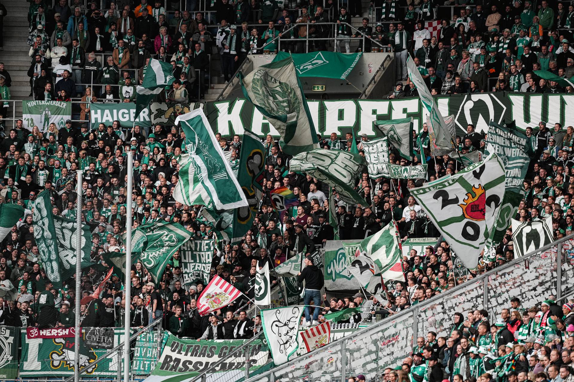 Die Werder-Fans im Gästeblock in Hoffenheim schwenken ihre Werder-Fahnen.