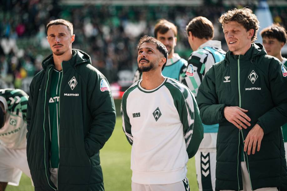 Leonardo Bittencourt blickt in Richtung der Fans in der Ostkurve und trägt einen Pullover.