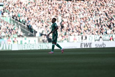 Felix Agu auf dem Platz im Werder-Trikot, im Hintergrund das Publikum.
