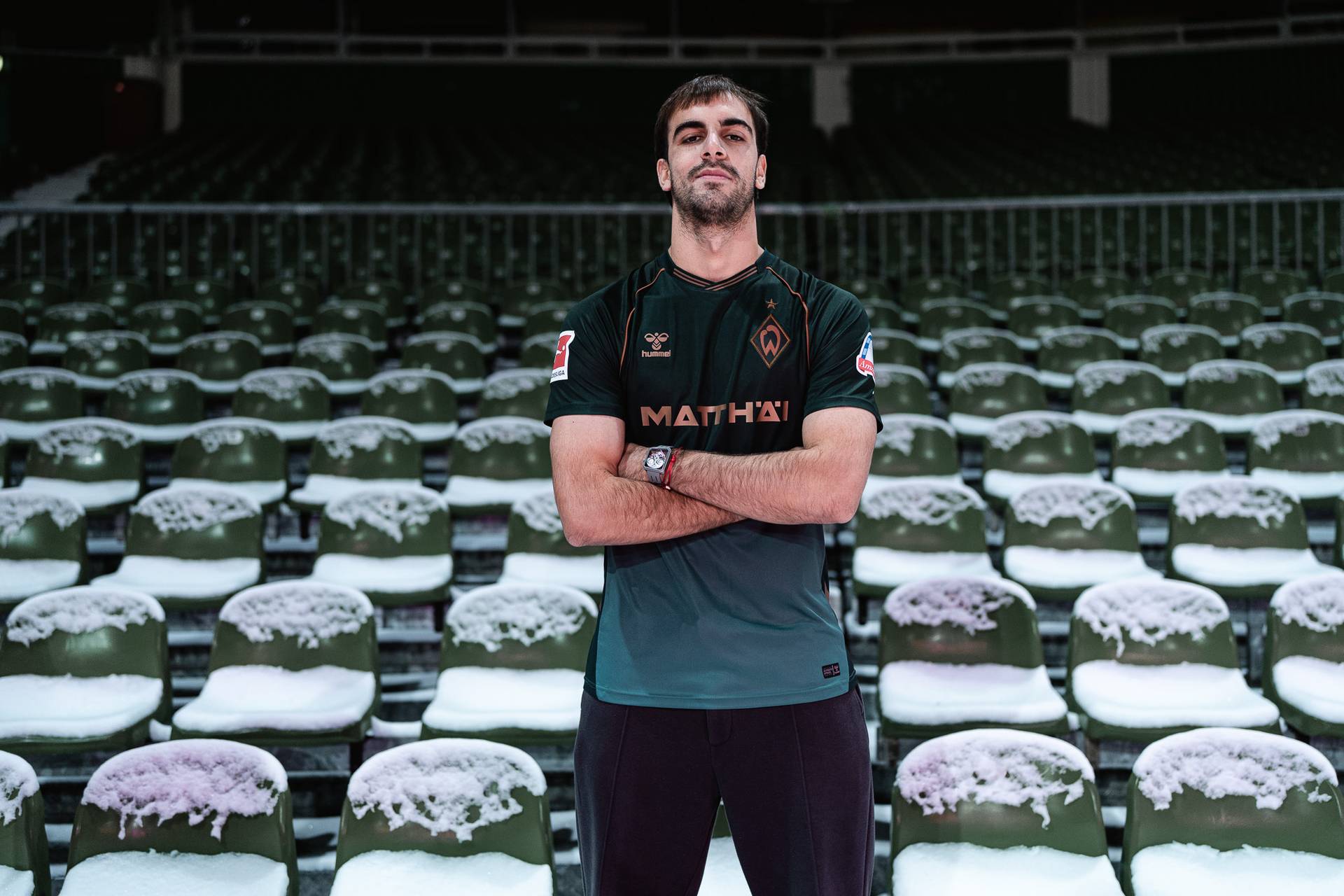 Jovan Milosevic steht mit verschränkten Armen auf der Tribüne im Weserstadion.