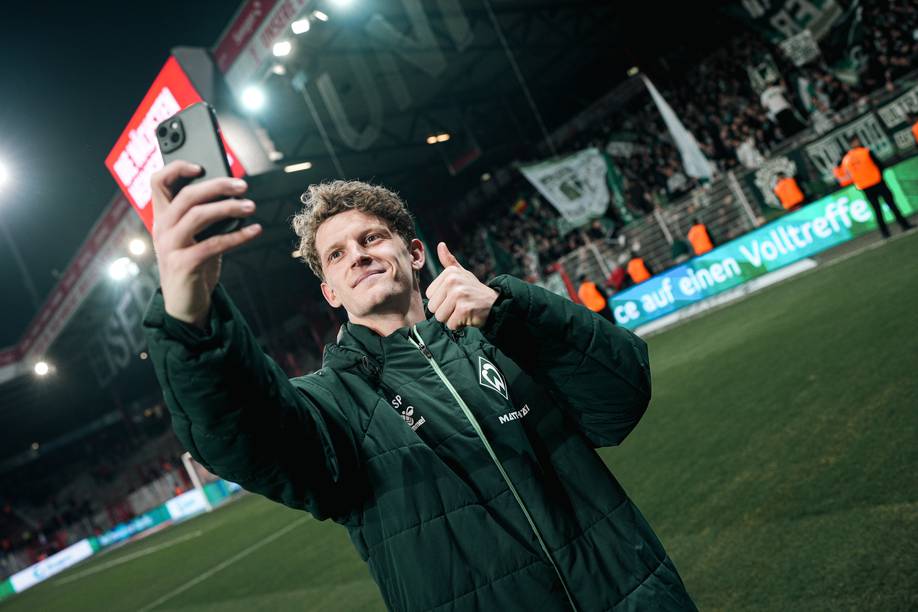 Jens Stage macht ein Selfie, im Hintergrund der Gästeblock.