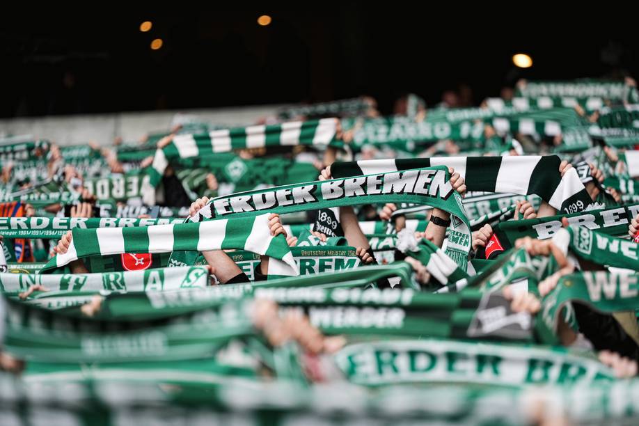 Ein Bild von Fans in der Ostkurve, die ihren Werder-Schal hochhalten.