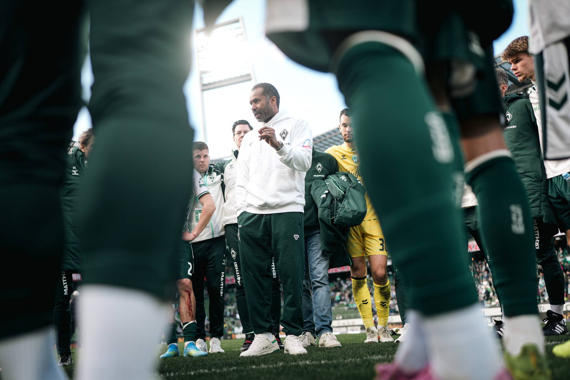Daniel Thioune spricht im Kreis zu der Mannschaft.