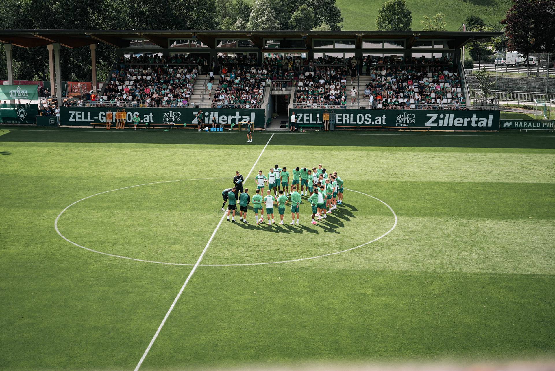 Die Mannschaft steht im Kreis im Mittelkreis auf dem Trainingsplatz.