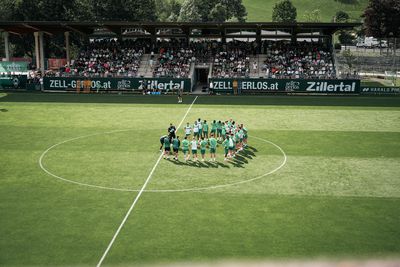 Die Mannschaft steht im Kreis im Mittelkreis auf dem Trainingsplatz.