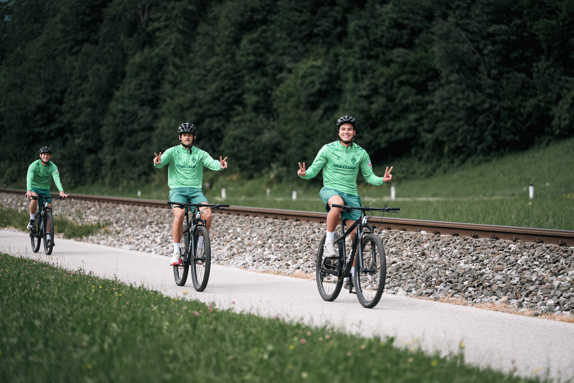 Stalmach und Kownacki grüßen auf ihren Fahrrädern in die Kamera.