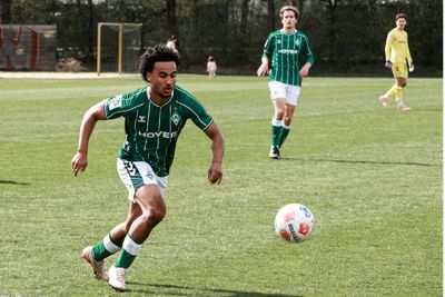 Ein Spieler der Werder-U19 im grün-weißen Dress läuft mit dem hochspringendem Ball in Richtung der rechten Bildhälfte