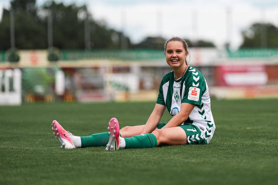 Lilli Purtscheller sitzt nach Spielende auf dem Platz und lacht in die Kamera.