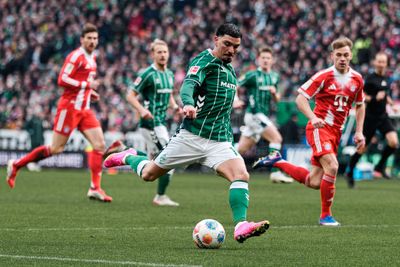 Cameron Puertas schießt. Im Hintergrund laufen links und rechts von ihm zwei Bayern-Spieler.