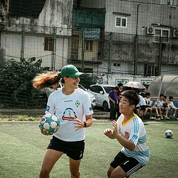 Hanna Nemeth spielt mit einem vietnamesischen Jungen. Beide lachen. 