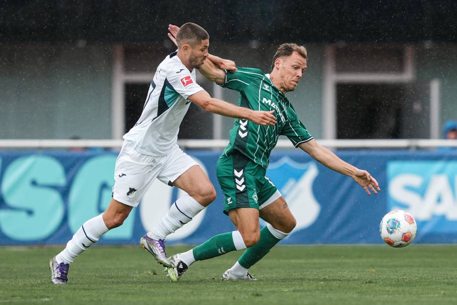 Senne Lynen im grünen Trikot kämpft mit Hoffenheims Andrej Kramaric im weißen Trikot um den Ball.
