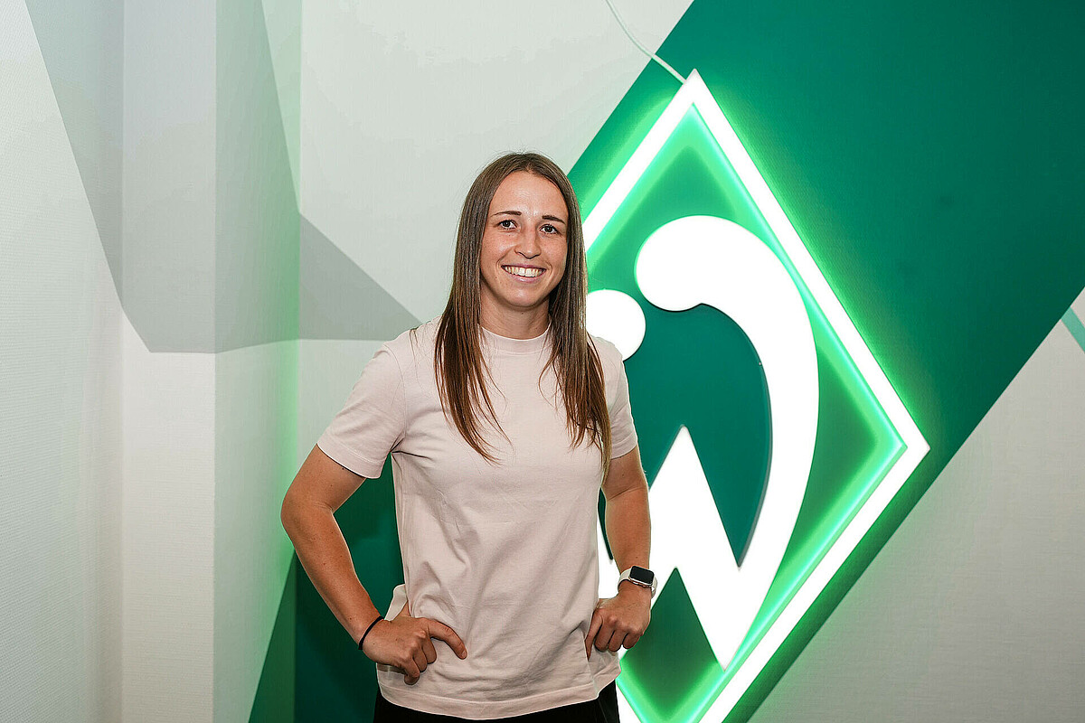 null Michaela Specht stützt die Arme in die Hüften und steht vor der Werder-Raute.