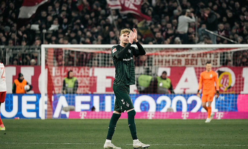 Nick Woltemade geht über den Rasen und klatscht.