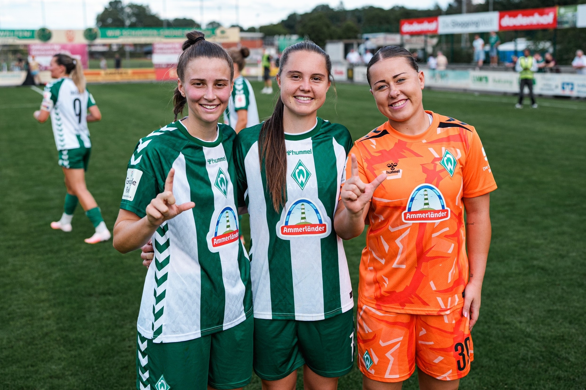 Julia Mager, Lilli Purtscheller und Mariella El Sherif lachen nach dem Testspiel gegen den HSV in die Kamera. Magerl und El Sherif machen eine Geste mit der Hand, die ein "L" für Lilli darstellt.
