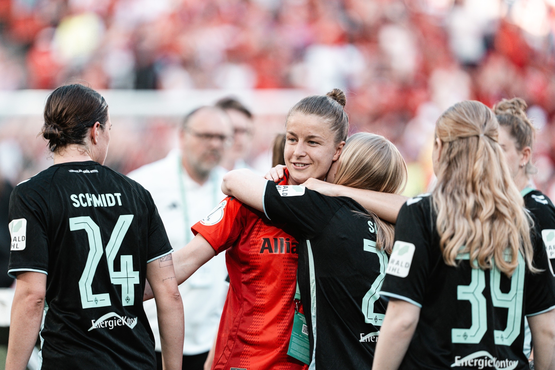 Michelle Ulbrich umarmt ihre ehemaligen Mitspielerinnen im Bayern-Trikot.