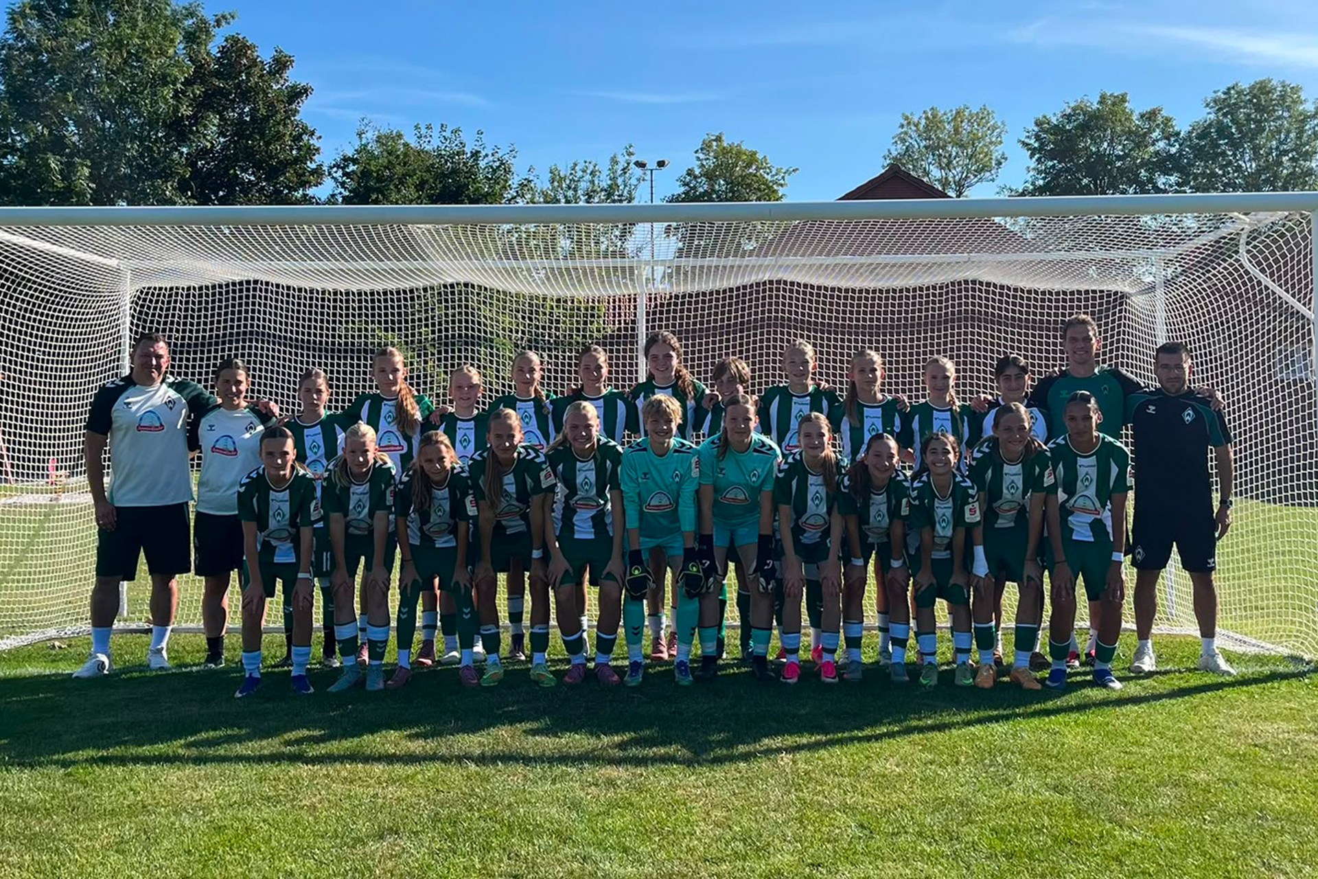 Die U15 steht für das Mannschaftsfoto zusammen und lächelt in die Kamera.