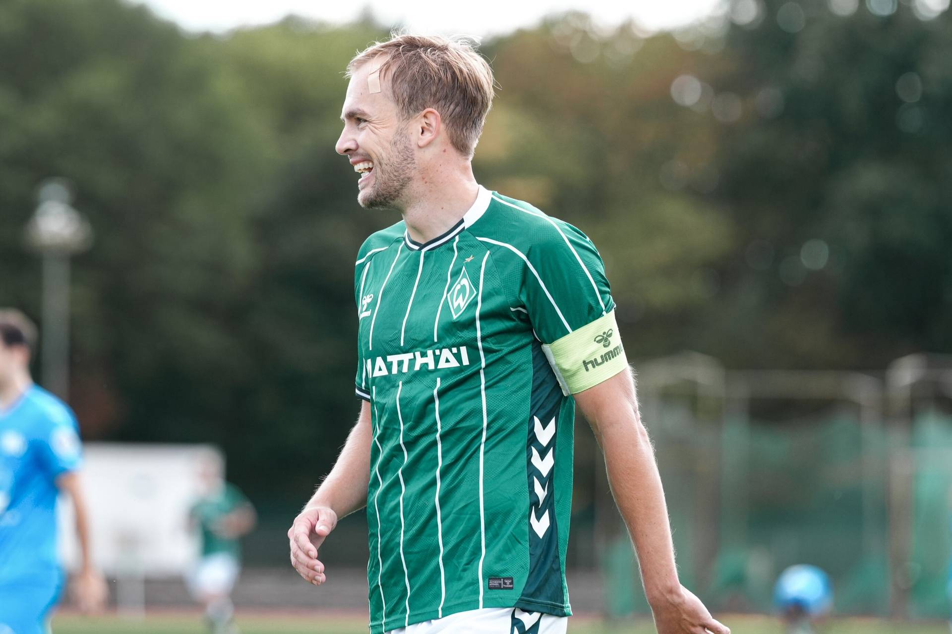 Cino Röcker im grünen Werder-Dress lächelt
