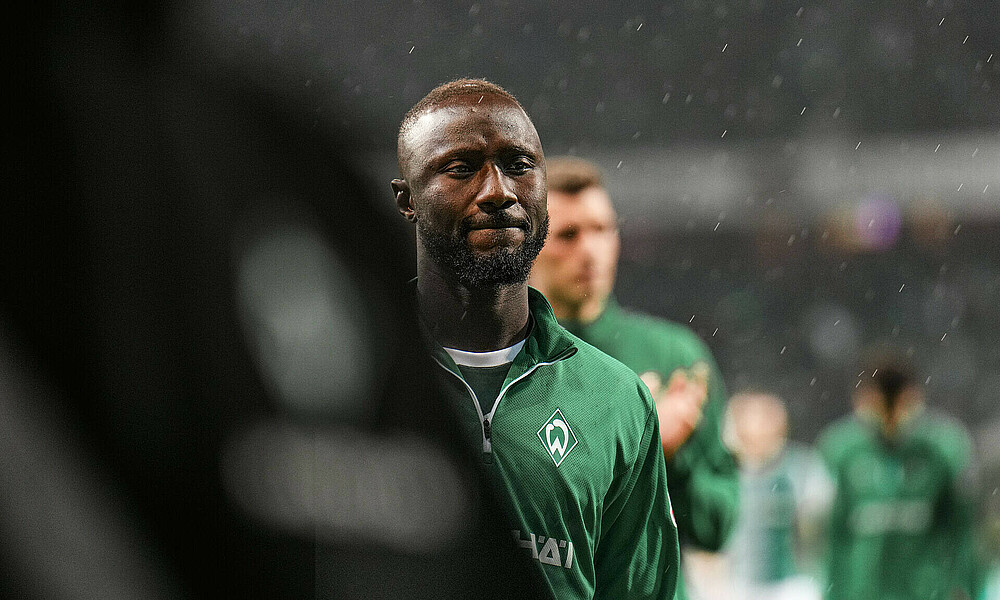 Naby Keïta im Regen. Er trägt den grünen Aufwärmpullover.