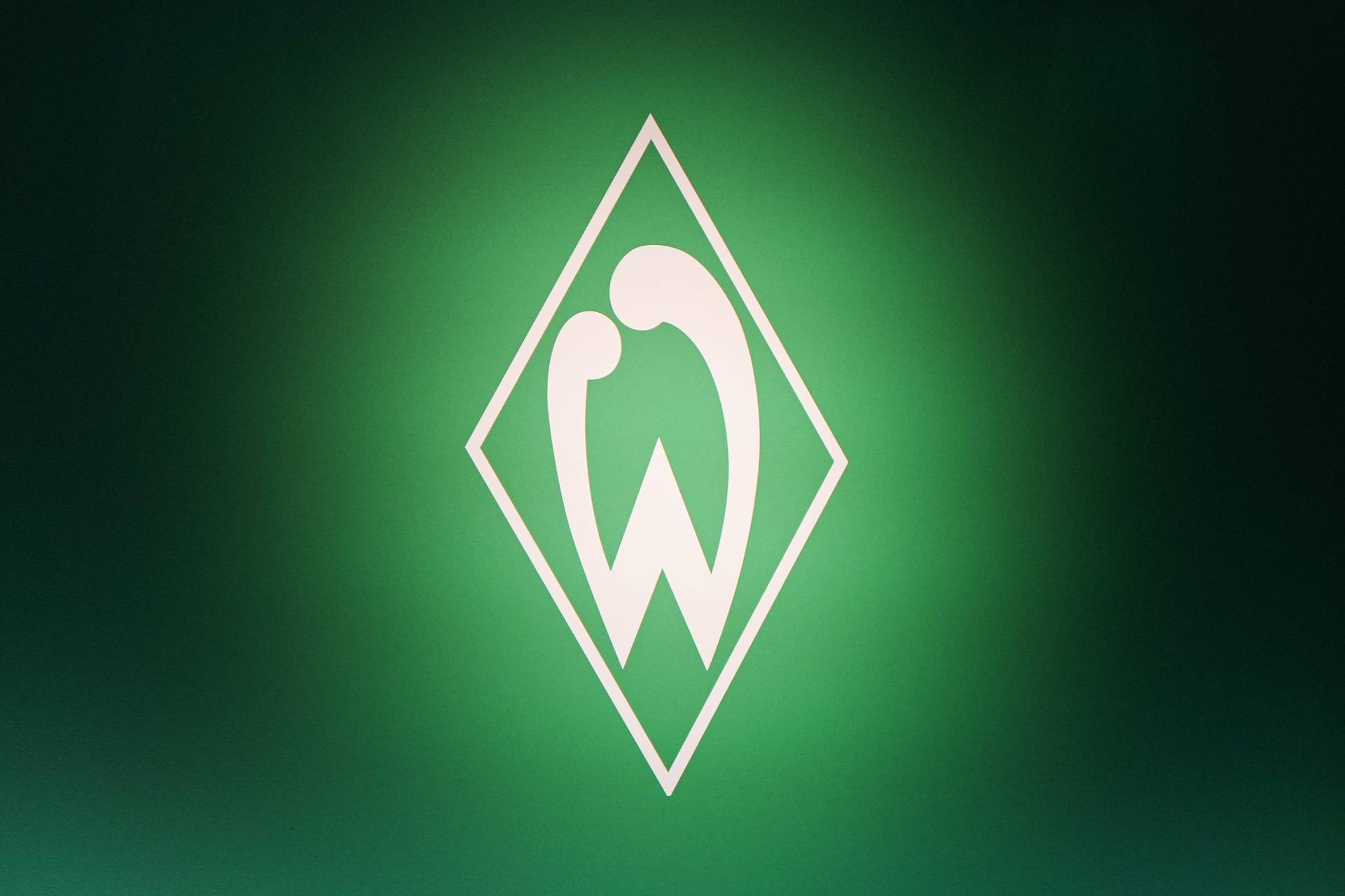 Eine Werder-Raute wird angestrahlt. Der Hintergrund ist dunkelgrün.