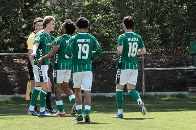 Vier Spieler der U19 laufen lachend aufeinander zu.