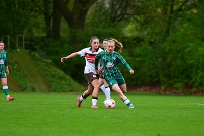 Eine Spielerin der 2. Frauen von Werder im grünen Dress dribbelt mit dem Ball im Zweikampf mit einer Gegnerin des FC St. Pauli