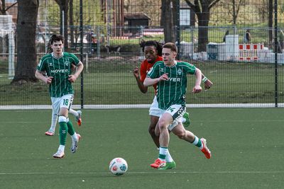 Ein Spieler von Werder Bremen läuft mit dem Ball und wird von einem Gegenspieler verfolgt.