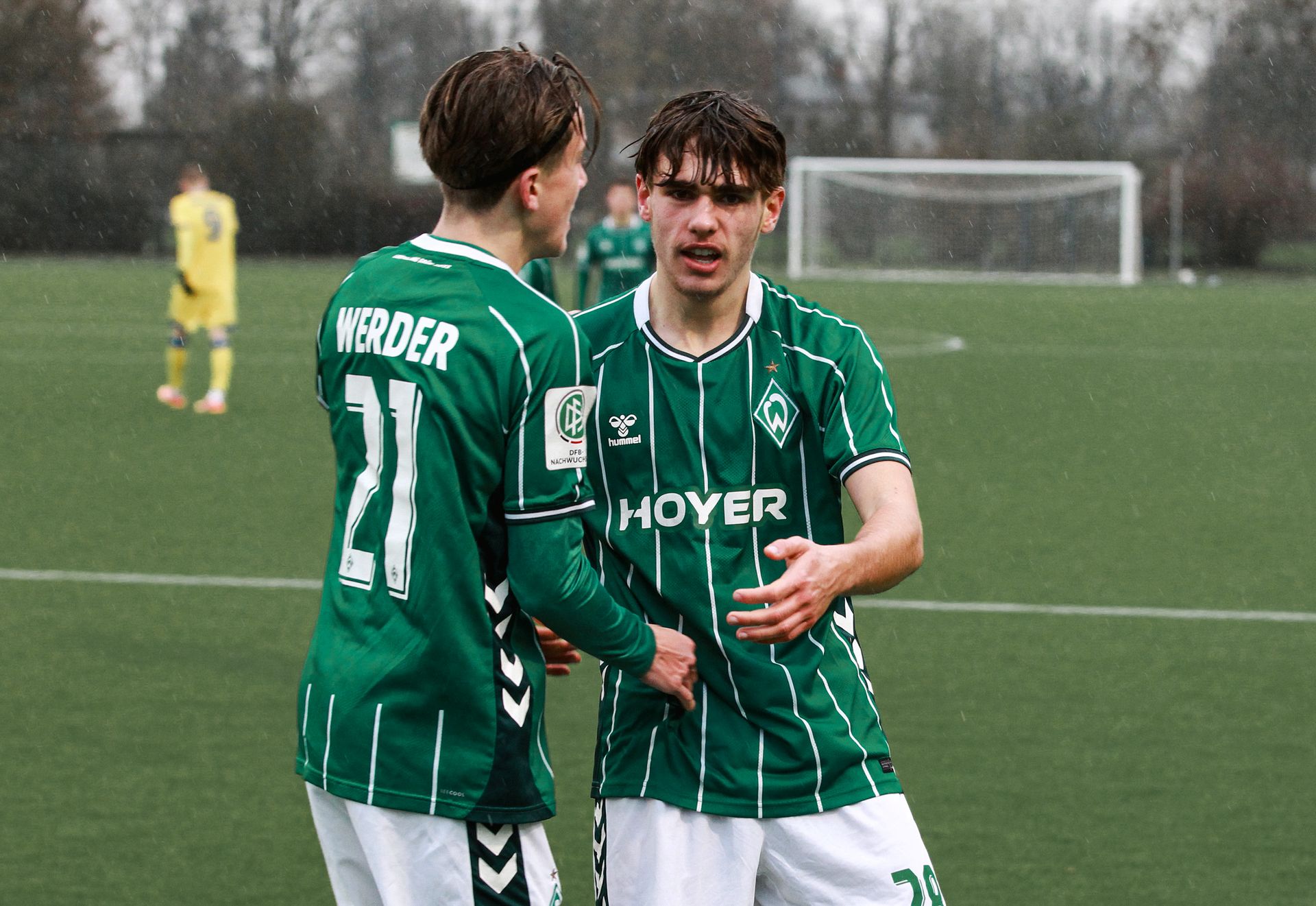 Ein Spieler der U19 schaut in die Kamera und jubelt, während ein zweiter ihn umarmt.