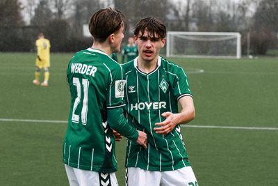 Ein Spieler der U19 schaut in die Kamera und jubelt, während ein zweiter ihn umarmt.