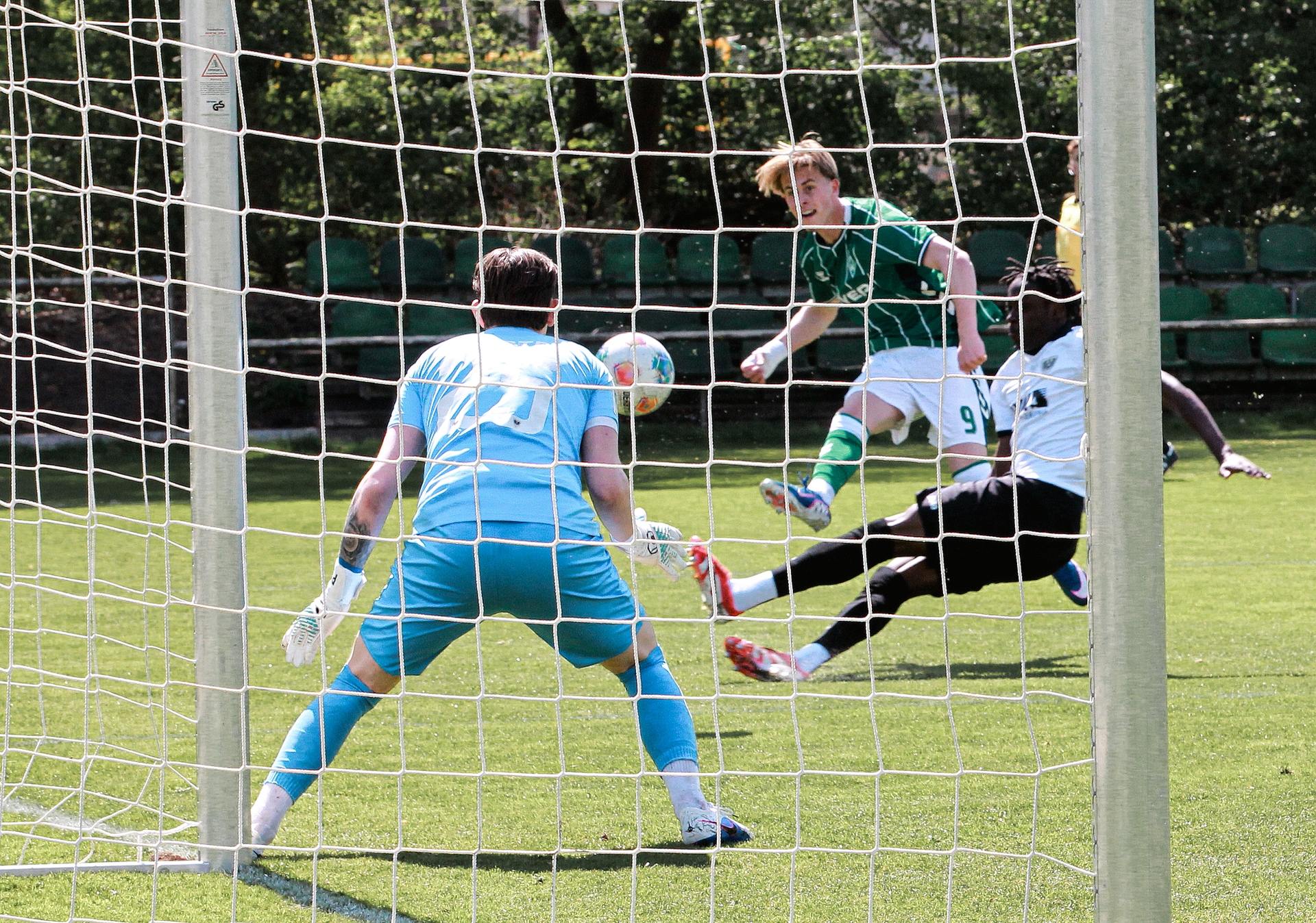 Noah Birkenpesch schießt den Ball aufs Tor, vor ihm grätscht ein Gegenspieler.