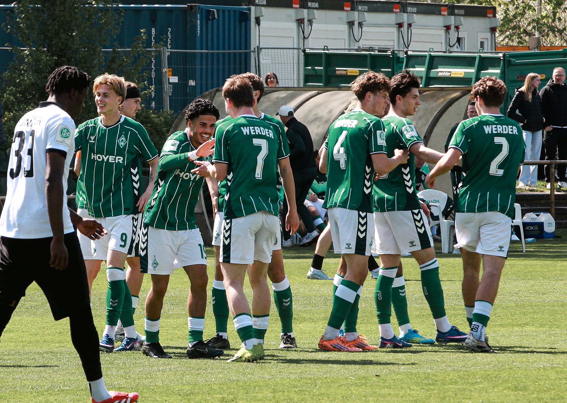 Spieler der U19 jubeln gemeinsam, während sich zwei Jungen abklatschen und lächeln.