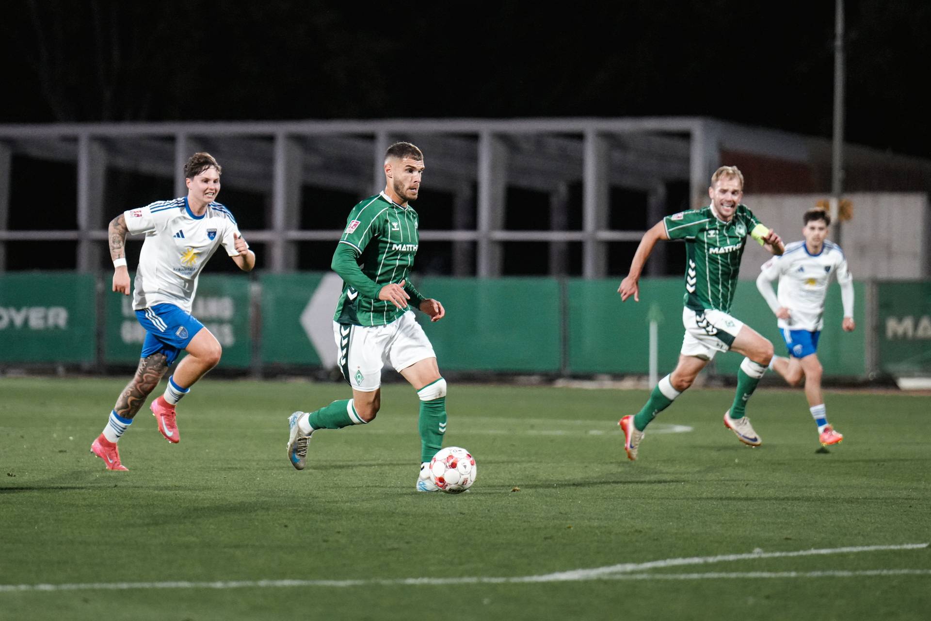 Christian Stark läuft mit dem Ball am Fuß auf das Tor der Gegner zu und wird von Gegenspielern verfolgt.